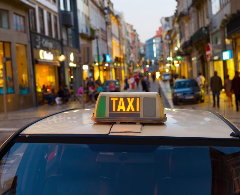 Taxi-Dachzeichen in einer belebten Stadtstraße bei Dämmerung.