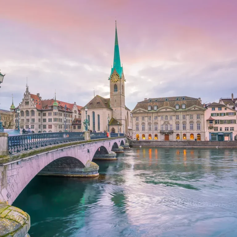 Zürich mit der Fraumünster-Kirche und der Limmat bei Sonnenuntergang.